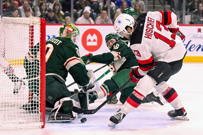 Jan 12, 2026; Saint Paul, Minnesota, USA;  Minnesota Wild goalie Jesper Wallstedt (30) makes a save on New Jersey Devils forward Nico Hischier (13) during the first period at Grand Casino Arena. Mandatory Credit: Nick Wosika-Imagn Images