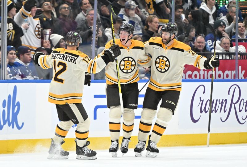 Dec 2, 2023; Toronto, Ontario, CAN; Boston Bruins forward Trent Frederic (11) celebrates with defensemen Kevin Shattenkirk (12) and Derek Forbort (28) after scoring against the Toronto Maple Leafs in the third period at Scotiabank Arena. Mandatory Credit: Dan Hamilton-USA TODAY Sports