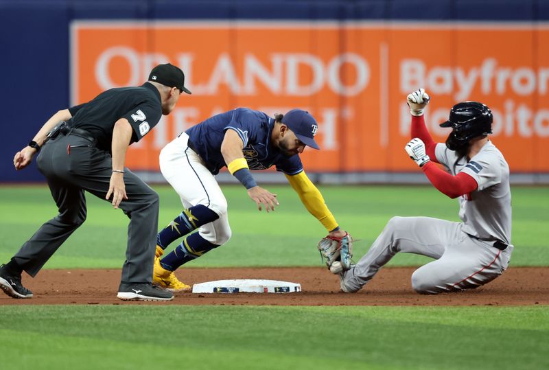 May 20, 2024; St. Petersburg, Florida, USA;  Tampa Bay Rays shortstop José Caballero (7) drops the ball as Boston Red Sox catcher Connor Wong (12) slides safe into second base during the ninth inning at Tropicana Field. Mandatory Credit: Kim Klement Neitzel-USA TODAY Sports