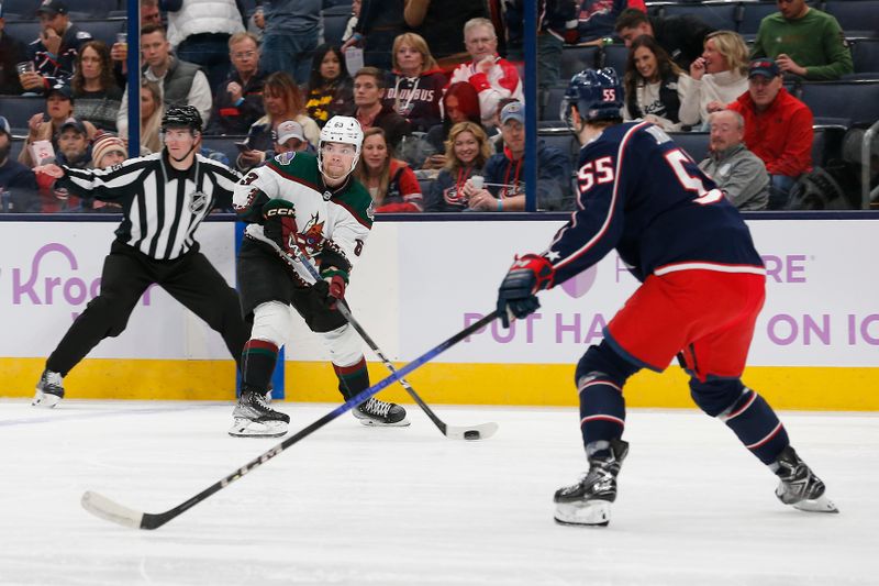 Nov 16, 2023; Columbus, Ohio, USA; Arizona Coyotes left wing Matias Maccelli (63) looks to pass as Columbus Blue Jackets defenseman David Jiricek (55) defends during the first period at Nationwide Arena. Mandatory Credit: Russell LaBounty-USA TODAY Sports