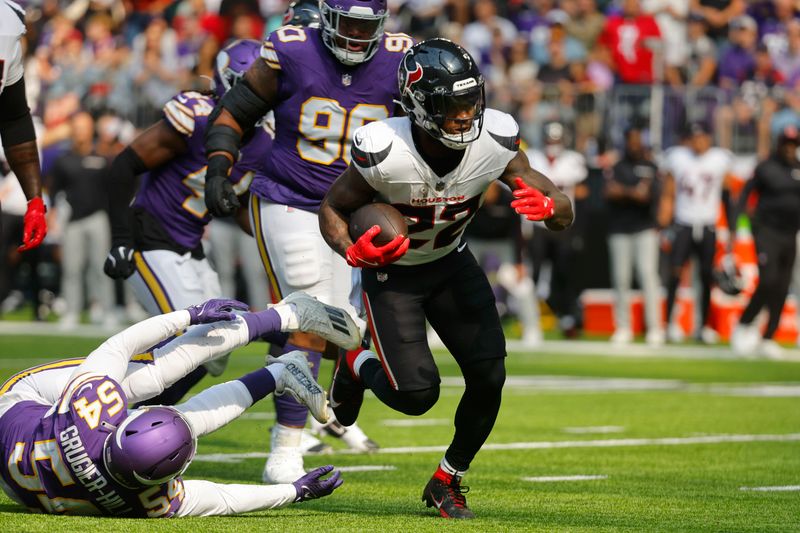 Houston Texans running back Cam Akers (22) runs from Minnesota Vikings linebacker Kamu Grugier-Hill (54) during the first half of an NFL football game, Sunday, Sept. 22, 2024, in Minneapolis. (AP Photo/Bruce Kluckhohn)