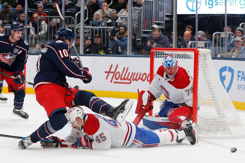 Nov 17, 2025; Columbus, Ohio, USA; Columbus Blue Jackets left wing Dmitri Voronkov (10) falls to the ice over the sliding Montreal Canadiens defenseman  Alexandre Carrier (45) during the second period at Nationwide Arena. Mandatory Credit: Russell LaBounty-Imagn Images
