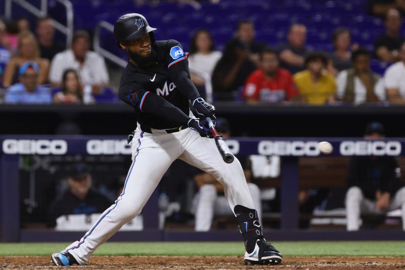 Jun 21, 2024; Miami, Florida, USA; Miami Marlins left fielder Bryan De La Cruz (14) hits a single against the Seattle Mariners during the ninth inning at loanDepot Park. Mandatory Credit: Sam Navarro-USA TODAY Sports