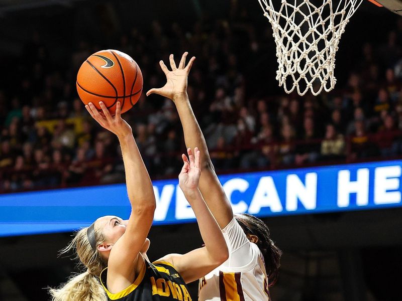 Feb 28, 2024; Minneapolis, Minnesota, USA; Iowa Hawkeyes guard Kylie Feuerbach (4) shoots as Minnesota Golden Gophers forward Niamya Holloway (41) defend during the second half at Williams Arena. Mandatory Credit: Matt Krohn-USA TODAY Sports