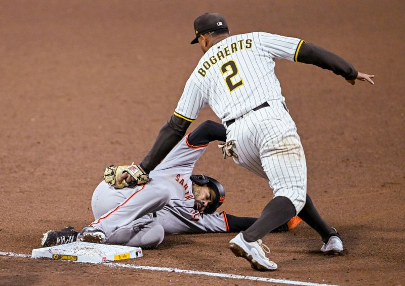 Apr 29, 2025; San Diego, California, USA; San Francisco Giants first baseman LaMonte Wade Jr. (31) slides safely into third ahead of the tag by San Diego Padres shortstop Xander Bogaerts (2) during the sixth inning at Petco Park. Mandatory Credit: Denis Poroy-Imagn Images