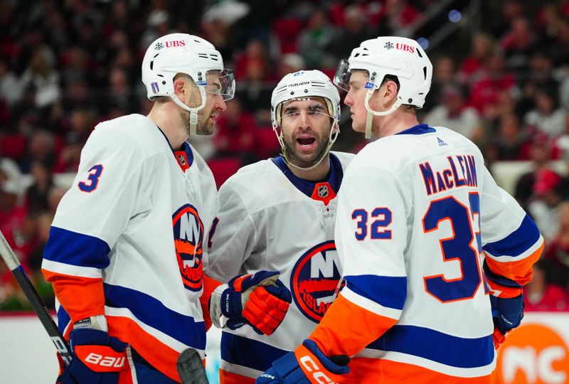 Apr 22, 2024; Raleigh, North Carolina, USA; New York  New York Islanders center Bo Horvat (14) center Kyle Palmieri (21) and center Kyle MacLean (32) talk against the Carolina Hurricanes during the third period in game two of the first round of the 2024 Stanley Cup Playoffs at PNC Arena. Mandatory Credit: James Guillory-USA TODAY Sports