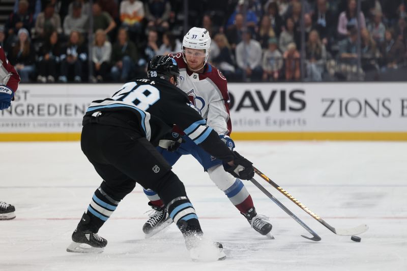 Oct 24, 2024; Salt Lake City, Utah, USA; Colorado Avalanche center Casey Mittelstadt (37) and Utah Hockey Club defenseman Ian Cole (28) battle for the puck during the first period at Delta Center. Mandatory Credit: Rob Gray-Imagn Images