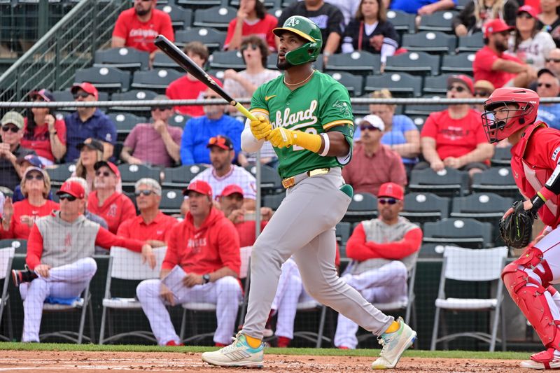 Mar 6, 2024; Tempe, Arizona, USA;  Oakland Athletics right fielder Miguel Andujar (22) hits a three run home run in the first inning against the Los Angeles Angels during a spring training game at Tempe Diablo Stadium. Mandatory Credit: Matt Kartozian-USA TODAY Sports