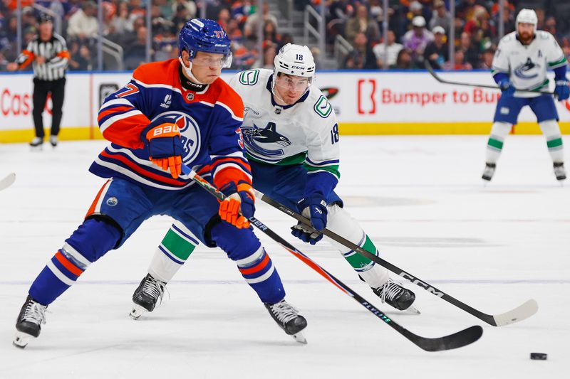 Sep 28, 2025; Edmonton, Alberta, CAN; Edmonton Oilers defensemen Atro Leppanen (37) moves the puck in front of Vancouver Canucks forward Drew O'Connor (18) during the second period at Rogers Place. Mandatory Credit: Perry Nelson-Imagn Images