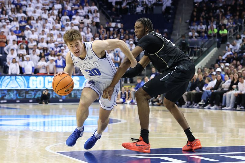 Feb 13, 2024; Provo, Utah, USA; Brigham Young Cougars guard Dallin Hall (30) drives against Central Florida Knights forward Omar Payne (5) during the second half at Marriott Center. Mandatory Credit: Rob Gray-USA TODAY Sports