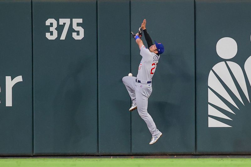 Sep 28, 2023; Atlanta, Georgia, USA; Chicago Cubs right fielder Seiya Suzuki (27) reaches for a fly ball against the Atlanta Braves in the third inning at Truist Park. Mandatory Credit: Brett Davis-USA TODAY Sports