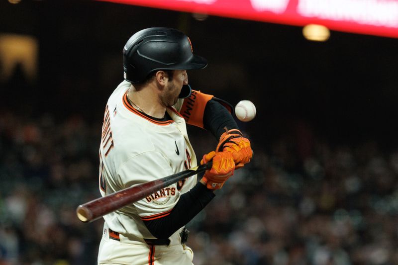 Jun 25, 2025; San Francisco, California, USA; San Francisco Giants first baseman Casey Schmitt (10) is hit by a pitch during the ninth inning against the Miami Marlins at Oracle Park. Mandatory Credit: Sergio Estrada-Imagn Images