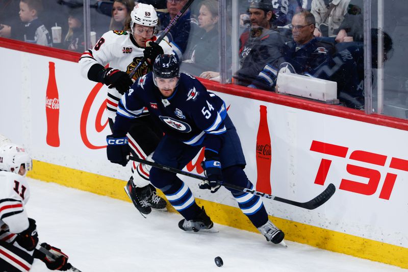 Mar 3, 2026; Winnipeg, Manitoba, CAN;  Winnipeg Jets defenseman Dylan Samberg (54) skates against Chicago Blackhawks forward Tyler Bertuzzi (59) during the third period at Canada Life Centre. Mandatory Credit: Terrence Lee-Imagn Images
