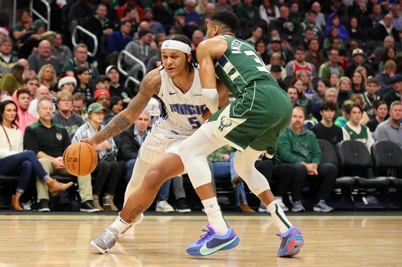 MILWAUKEE, WISCONSIN - DECEMBER 21: Paolo Banchero #5 of the Orlando Magic is defended by Giannis Antetokounmpo #34 of the Milwaukee Bucks during the second half of a game at Fiserv Forum on December 21, 2023 in Milwaukee, Wisconsin. NOTE TO USER: User expressly acknowledges and agrees that, by downloading and or using this photograph, User is consenting to the terms and conditions of the Getty Images License Agreement. (Photo by Stacy Revere/Getty Images)