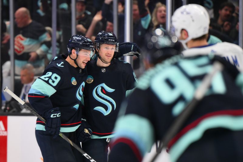Feb 22, 2024; Seattle, Washington, USA; Seattle Kraken defenseman Vince Dunn (29) and left wing Jared McCann (19) celebrate after McCann scored a goal against the Vancouver Canucks during the second period at Climate Pledge Arena. Mandatory Credit: Steven Bisig-USA TODAY Sports
