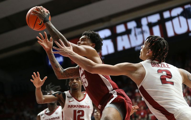 Mar 9, 2024; Tuscaloosa, Alabama, USA;  Alabama guard Aaron Estrada goes for a shot between Arkansas guard Tramon Mark (12) and Arkansas forward Trevon Brazile (2) at Coleman Coliseum. Alabama came from behind to win on overtime 92-88. Mandatory Credit: Gary Cosby Jr.-USA TODAY Sports