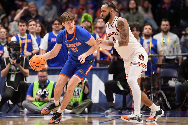 Mar 17, 2024; Nashville, TN, USA; Florida Gators forward Alex Condon (21) controls the ball against Auburn Tigers forward Johni Broome (4) in the second half in the SEC Tournament championship game at Bridgestone Arena. Mandatory Credit: Steve Roberts-USA TODAY Sports