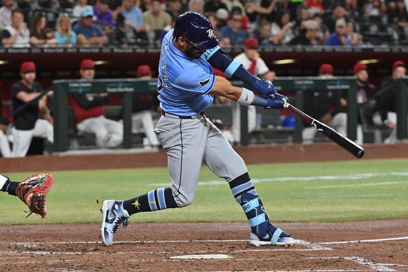 Apr 24, 2025; Phoenix, Arizona, USA;  Tampa Bay Rays shortstop José Caballero (77) hits an RBI double in the fifth inning against the Arizona Diamondbacks at Chase Field. Mandatory Credit: Matt Kartozian-Imagn Images