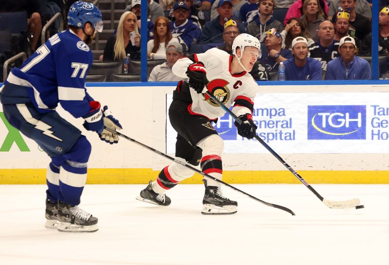 Apr 11, 2024; Tampa, Florida, USA; Ottawa Senators left wing Brady Tkachuk (7) passes the puck as Tampa Bay Lightning defenseman Victor Hedman (77) defends during overtime at Amalie Arena. Mandatory Credit: Kim Klement Neitzel-USA TODAY Sports