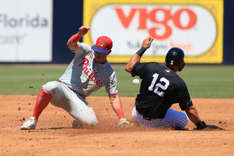 Mar 22, 2026; Tampa, Florida, USA; Philadelphia Phillies infielder Dylan Moore (25) attempted to tag out New York Yankees center fielder Trent Grisham (12) at George M. Steinbrenner Field. Mandatory Credit: Kim Klement Neitzel-Imagn Images