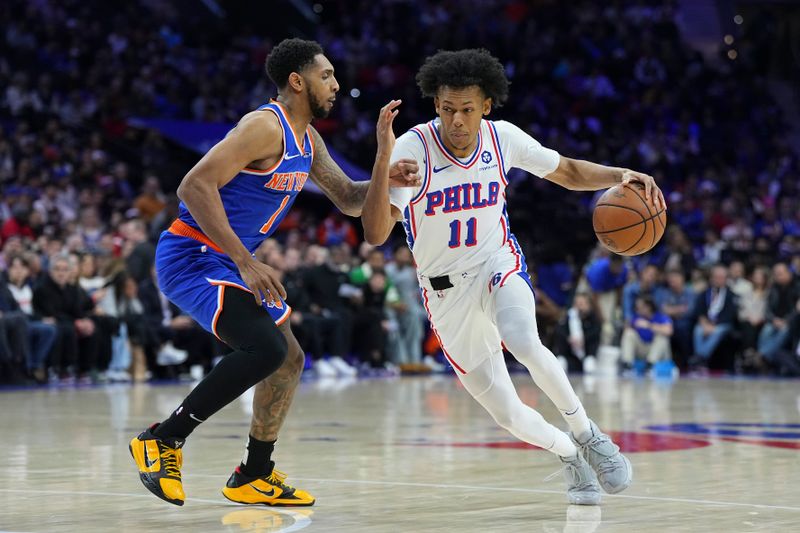 PHILADELPHIA, PENNSYLVANIA - JANUARY 15: Jeff Dowtin Jr. #11 of the Philadelphia 76ers dribbles the ball to the basket against Cameron Payne #1 of the New York Knicks in the first half at the Wells Fargo Center on January 15, 2025 in Philadelphia, Pennsylvania. NOTE TO USER: User expressly acknowledges and agrees that, by downloading and/or using this photograph, user is consenting to the terms and conditions of the Getty Images License Agreement. (Photo by Mitchell Leff/Getty Images)