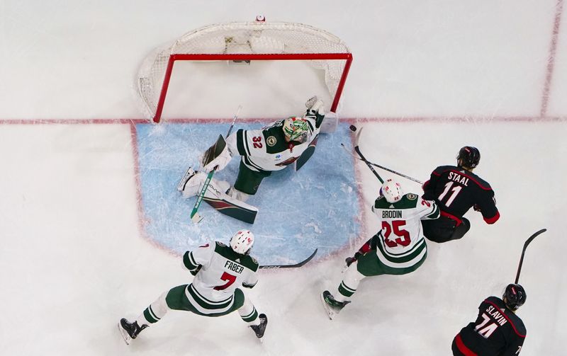 Jan 21, 2024; Raleigh, North Carolina, USA;  Minnesota Wild goaltender Filip Gustavsson (32) stops the scoring attempt by Carolina Hurricanes center Jordan Staal (11) during the third period at PNC Arena. Mandatory Credit: James Guillory-USA TODAY Sports