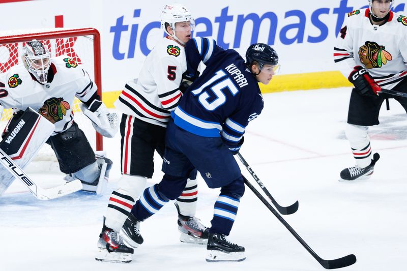 Oct 11, 2024; Winnipeg, Manitoba, CAN;  Chicago Blackhawks defenseman Connor Murphy (5) jostles for position with Winnipeg Jets forward Rasmus Kupari (15) during the third period at Canada Life Centre. Mandatory Credit: Terrence Lee-Imagn Images