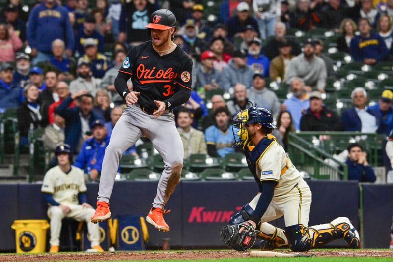 May 21, 2025; Milwaukee, Wisconsin, USA;  Baltimore Orioles first baseman Ryan O'Hearn (32) reacts after scoring a run as Milwaukee Brewers catcher Eric Haase (13) looks on in the eighth inning at American Family Field. Mandatory Credit: Benny Sieu-Imagn Images