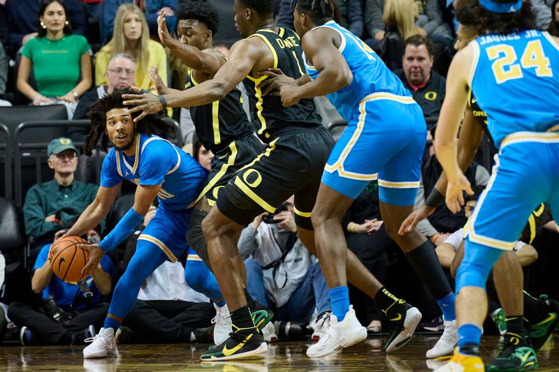 Feb 11, 2023; Eugene, Oregon, USA; UCLA Bruins guard Tyger Campbell (10) is double teamed by Oregon Ducks guard Jermaine Couisnard (5) and center N'Faly Dante (1) as he looks to pass the ball during the first half at Matthew Knight Arena. Mandatory Credit: Troy Wayrynen-USA TODAY Sports