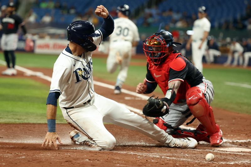 Sep 4, 2024; St. Petersburg, Florida, USA;  Tampa Bay Rays outfielder Dylan Carlson (10) scores a run as he slides into home plate after Minnesota Twins catcher Christian Vazquez (8) missed the ball during the fourth inning at Tropicana Field. Mandatory Credit: Kim Klement Neitzel-Imagn Images