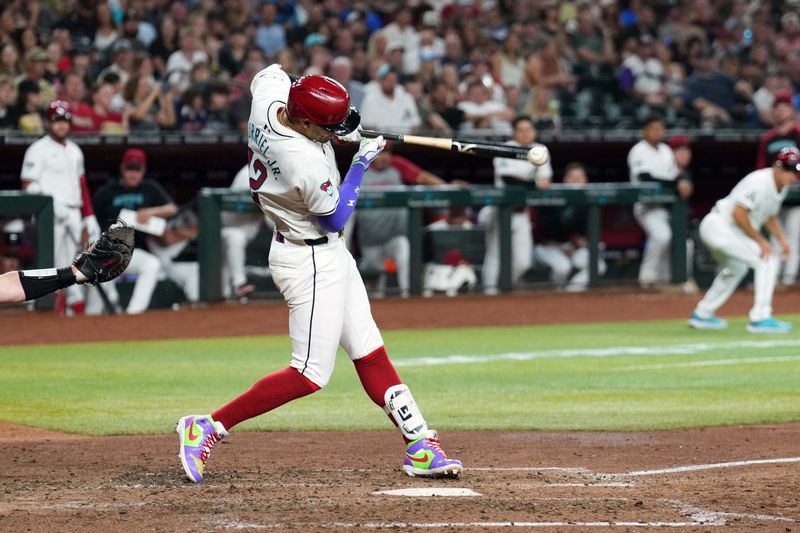 Jul 13, 2024; Phoenix, Arizona, USA; Arizona Diamondbacks outfielder Lourdes Gurriel Jr. (12) hits an RBI singe against the Toronto Blue Jays during the fourth inning at Chase Field. Mandatory Credit: Joe Camporeale-USA TODAY Sports