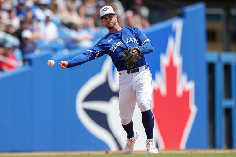 Mar 23, 2025; Dunedin, Florida, USA; Toronto Blue Jays third baseman Ernie Clement (22) throws to first base for an out against the Pittsburgh Pirates in the second inning during spring training at TD Ballpark. Mandatory Credit: Nathan Ray Seebeck-Imagn Images