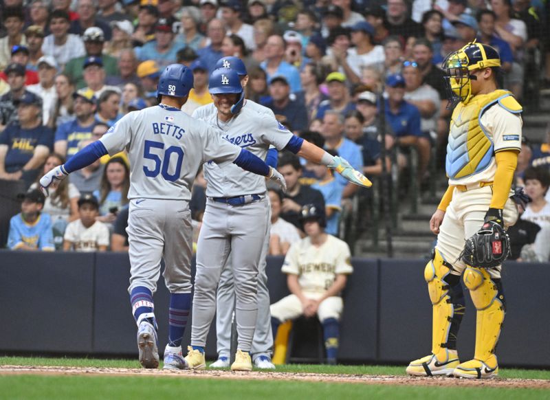 Aug 12, 2024; Milwaukee, Wisconsin, USA; Los Angeles Dodgers third base Enrique Hernández (8) contgratulates Los Angeles Dodgers outfielder Mookie Betts (50 after hitting home run against the Milwaukee Brewersin the third inning at American Family Field. Mandatory Credit: Michael McLoone-USA TODAY Sports