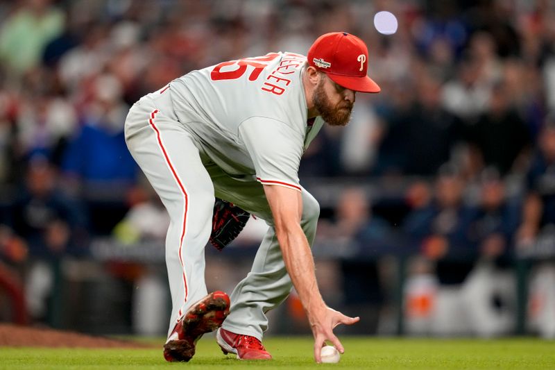 Oct 12, 2022; Atlanta, Georgia, USA; Philadelphia Phillies starting pitcher Zack Wheeler (45) fields the ball hit for an RBI single by Atlanta Braves third baseman Austin Riley (27) in the sixth inning during game two of the NLDS for the 2022 MLB Playoffs at Truist Park. Mandatory Credit: Dale Zanine-USA TODAY Sports