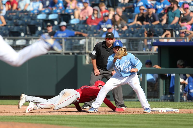 Jun 17, 2023; Kansas City, Missouri, USA; Los Angeles Angels outfielder Taylor Ward (3) slides safely back into first base as Kansas City Royals first baseman Nick Pratto (32) is late with the tag during the eighth inning at Kauffman Stadium. Mandatory Credit: Scott Sewell-USA TODAY Sports
