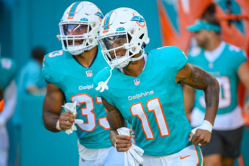 Miami Dolphins wide receiver Cedrick Wilson Jr. (11) runs onto the field with the team before the start an NFL pre-season football game against the Atlanta Falcons, Friday, Aug. 11, 2023, in Miami Gardens, Fla. (AP Photo/Doug Murray)