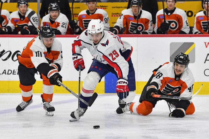 Apr 16, 2024; Philadelphia, Pennsylvania, USA; Washington Capitals center Hendrix Lapierre (29) battles for the puck Philadelphia Flyers right wing Bobby Brink (10) and  center Morgan Frost (48) during the first period at Wells Fargo Center. Mandatory Credit: Eric Hartline-USA TODAY Sports