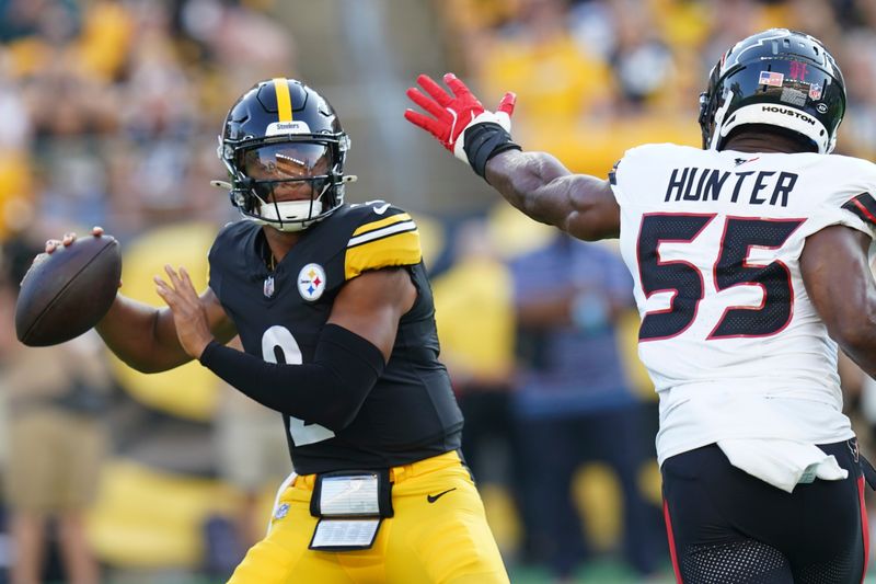 Pittsburgh Steelers quarterback Justin Fields (2) passes under pressure from Houston Texans defensive end Danielle Hunter (55) in the first half of a preseason NFL football game, Friday, Aug. 9, 2024, in Pittsburgh. (AP Photo/Matt Freed)