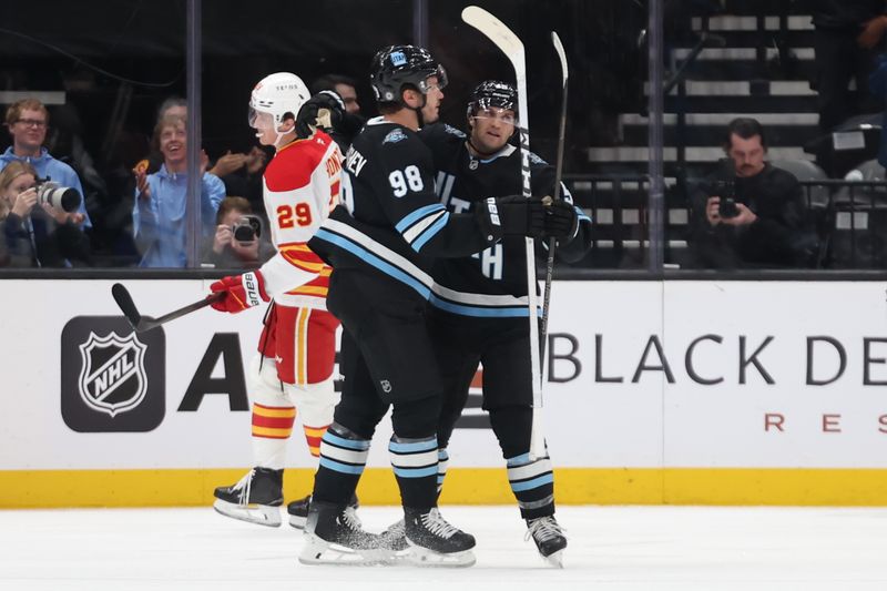 Oct 30, 2024; Salt Lake City, Utah, USA; Utah Hockey Club center Alexander Kerfoot (15) celebrates with defenseman Mikhail Sergachev (98) after Kerfoot scored a goal against the Calgary Flames during the first period at Delta Center. Mandatory Credit: Rob Gray-Imagn Images