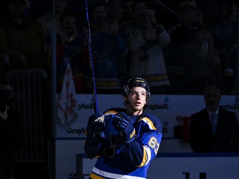 Feb 15, 2024; St. Louis, Missouri, USA;  St. Louis Blues left wing Jake Neighbours (63) salutes the fans after he was named second star of the game in a victory over the Edmonton Oilers at Enterprise Center. Mandatory Credit: Jeff Curry-USA TODAY Sports