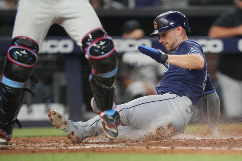 Jun 4, 2024; Miami, Florida, USA; Tampa Bay Rays second baseman Brandon Lowe (8) slides in safely to home plate in the fifth inning against the Tampa Bay Rays at loanDepot Park. Mandatory Credit: Jim Rassol-USA TODAY Sports