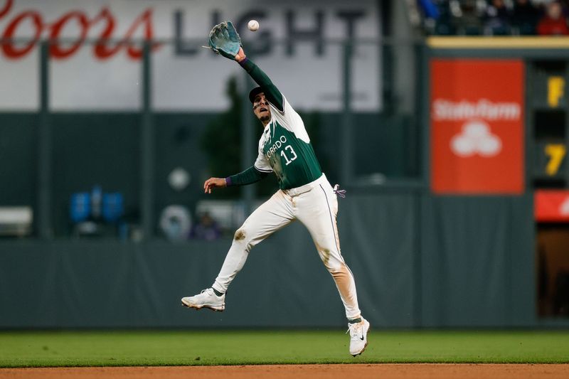 Apr 20, 2024; Denver, Colorado, USA; Colorado Rockies second baseman Alan Trejo (13) is unable to field a hit in the fifth inning against the Seattle Mariners at Coors Field. Mandatory Credit: Isaiah J. Downing-USA TODAY Sports