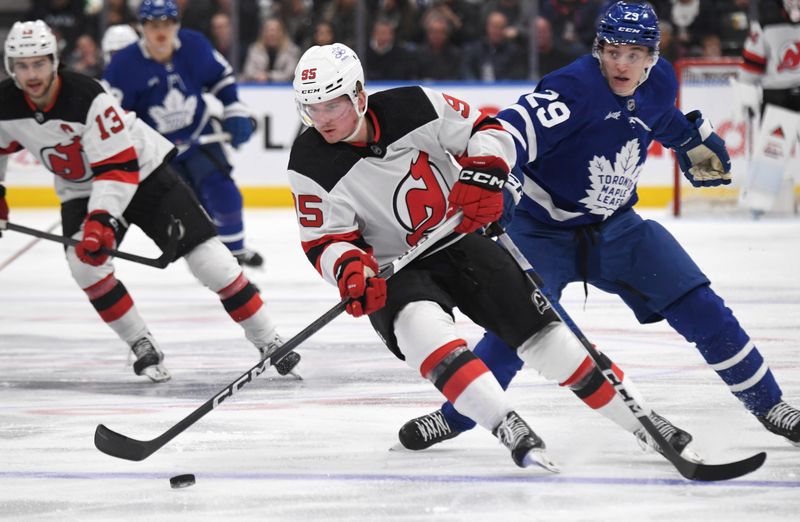 Apr 11, 2024; Toronto, Ontario, CAN; New Jersey Devils forward Graeme Clarke (95) skates with the puck past Toronto Maple Leafs forward Pontus Holmberg (29) in the second period at Scotiabank Arena. Mandatory Credit: Dan Hamilton-USA TODAY Sports