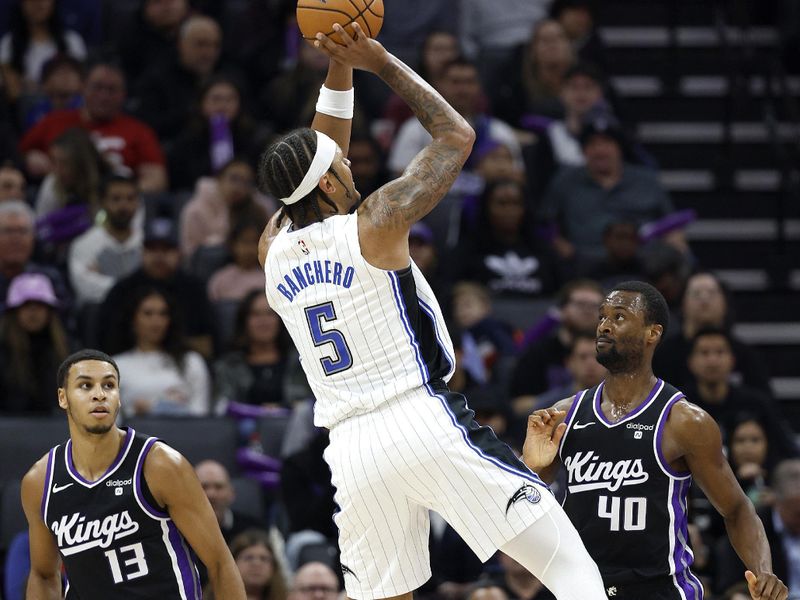 SACRAMENTO, CALIFORNIA - JANUARY 03: Paolo Banchero #5 of the Orlando Magic shoots over Keegan Murray #13 and Harrison Barnes #40 of the Sacramento Kings during the first half of an NBA basketball game at Golden 1 Center on January 03, 2024 in Sacramento, California. NOTE TO USER: User expressly acknowledges and agrees that, by downloading and or using this photograph, User is consenting to the terms and conditions of the Getty Images License Agreement. (Photo by Thearon W. Henderson/Getty Images)