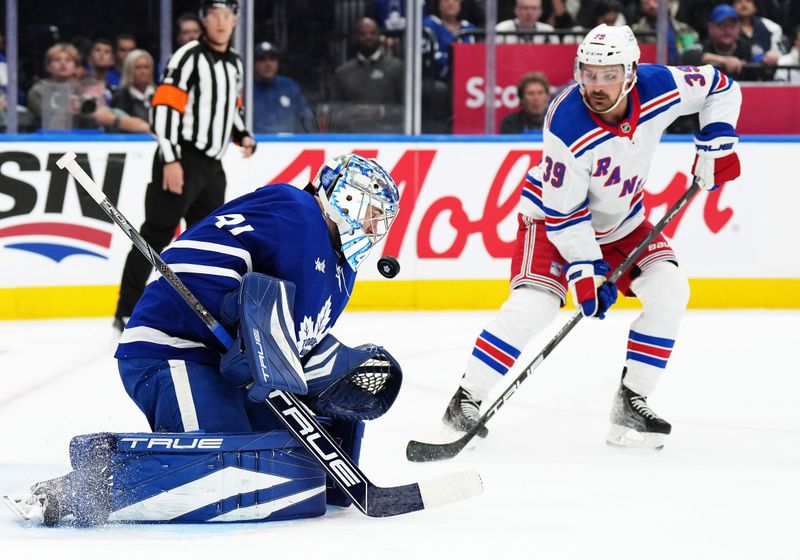 Oct 19, 2024; Toronto, Ontario, CAN; Toronto Maple Leafs goaltender Anthony Stolarz (41) stops a puck as New York Rangers center Sam Carrick (39) looks for a rebound during the second period at Scotiabank Arena. Mandatory Credit: Nick Turchiaro-Imagn Images