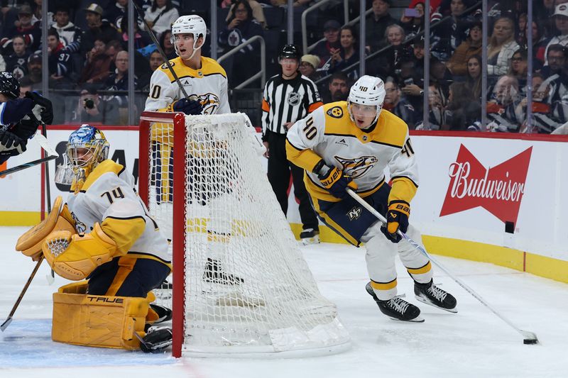 Oct 18, 2025; Winnipeg, Manitoba, CAN; Nashville Predators center Fedor Svechkov (40) skates around Nashville Predators goaltender Juuse Saros (74) against the Winnipeg Jets during the second period at Canada Life Centre. Mandatory Credit: James Carey Lauder-Imagn Images
