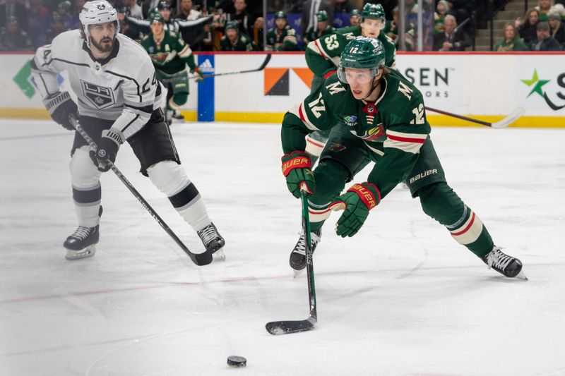 Feb 21, 2023; Saint Paul, Minnesota, USA; Minnesota Wild left wing Matt Boldy (12) and Los Angeles Kings center Phillip Danault (24) chase the puck in the second period at Xcel Energy Center. Mandatory Credit: Matt Blewett-USA TODAY Sports