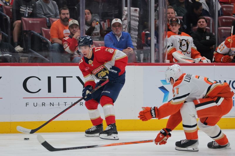 Jan 18, 2025; Sunrise, Florida, USA; Florida Panthers center Evan Rodrigues (17) moves the puck as Anaheim Ducks center Isac Lundestrom (21) defends during the first period at Amerant Bank Arena. Mandatory Credit: Sam Navarro-Imagn Images