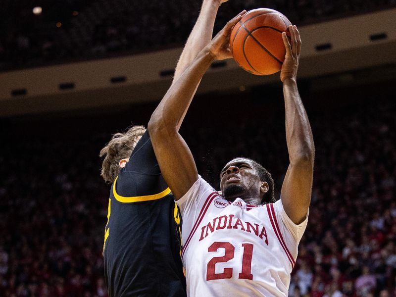 Jan 30, 2024; Bloomington, Indiana, USA; Indiana Hoosiers forward Mackenzie Mgbako (21) shoots the ball while Iowa Hawkeyes forward Ben Krikke (23) defends in the first half at Simon Skjodt Assembly Hall. Mandatory Credit: Trevor Ruszkowski-USA TODAY Sports