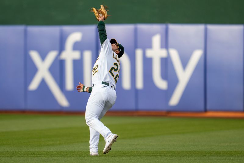 Jun 13, 2023; Oakland, California, USA; Oakland Athletics right fielder Ramon Laureano (22) fields a fly ball against the Tampa Bay Rays during the fourth inning at Oakland-Alameda County Coliseum. Mandatory Credit: Neville E. Guard-USA TODAY Sports